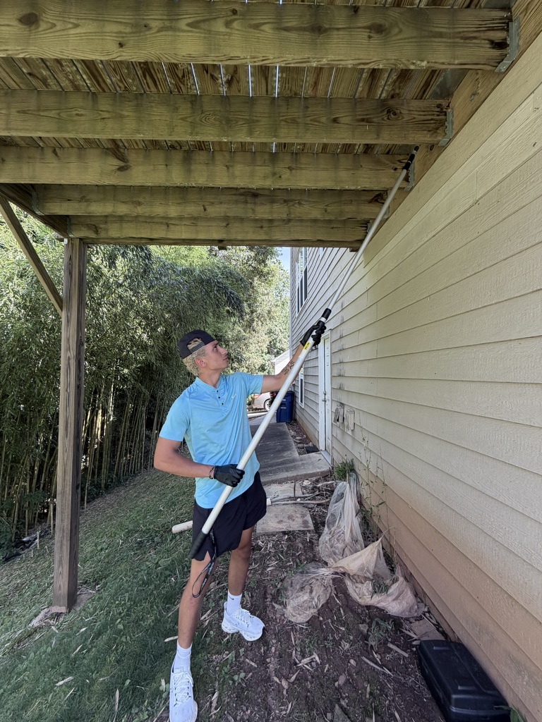 Hazz servicing the eaves of a house in a ProForce polo